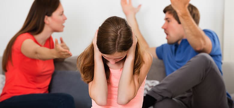 Parents arguing with child in the room, child cover her ears