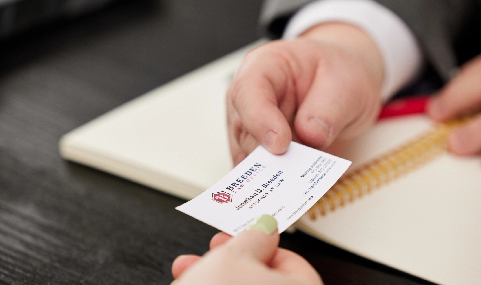 Breeden Law office business card being handed to client