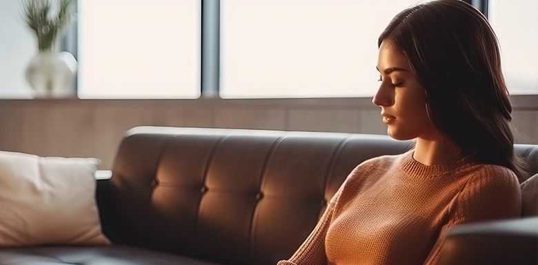 Woman sitting alone inside on leather couch
