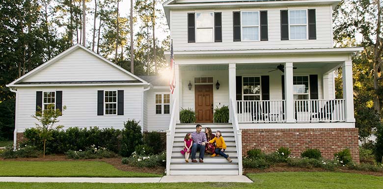 Family sitting on front steps of house