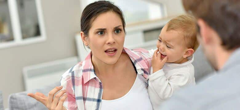 Mother upset, fighting with man, while holding crying child