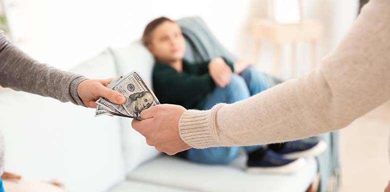 Parents exchanging money while child sits in background