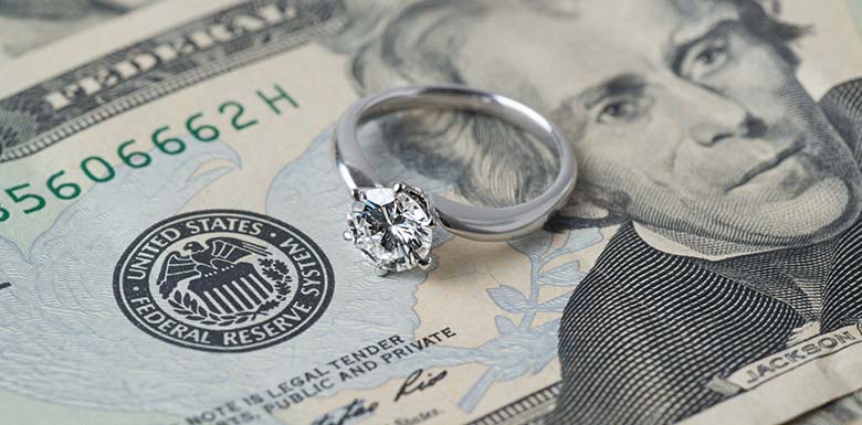 U.S. currency bills and wedding ring