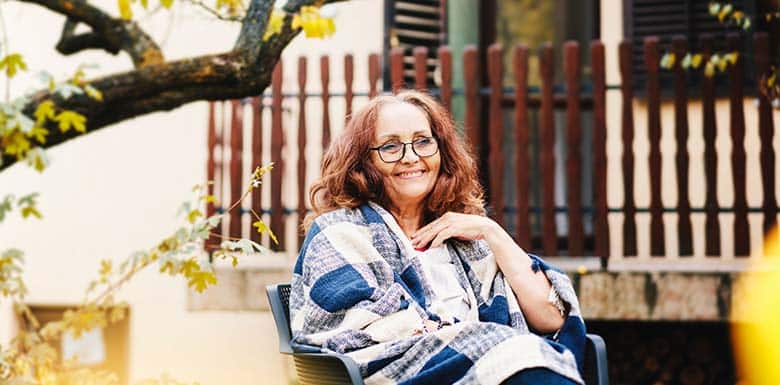 Older woman sitting outside with blanket