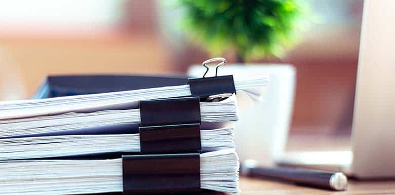 Stacks of paperwork held together by large clips