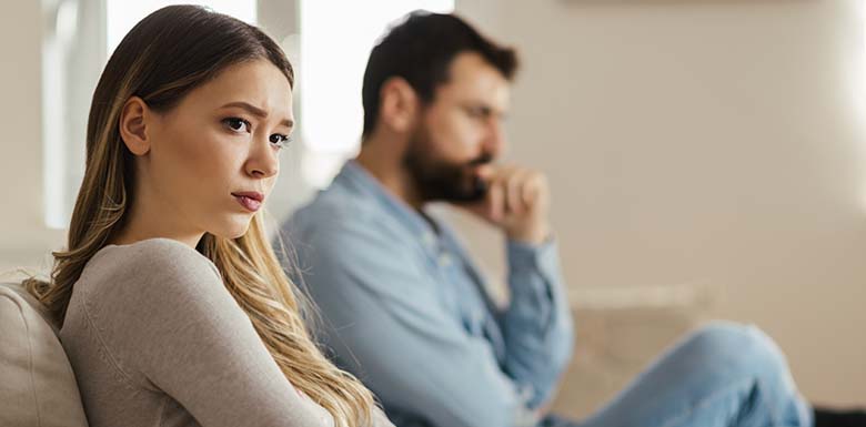 Man and woman looking upset on couch