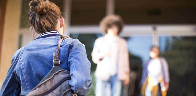 Teenager walking into school alone