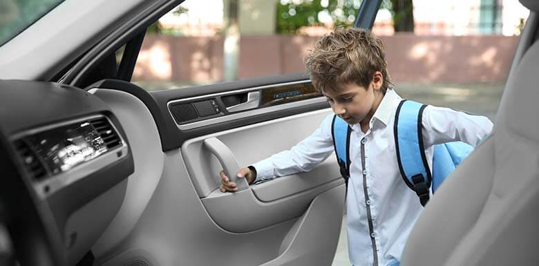 Young boy getting into car alone