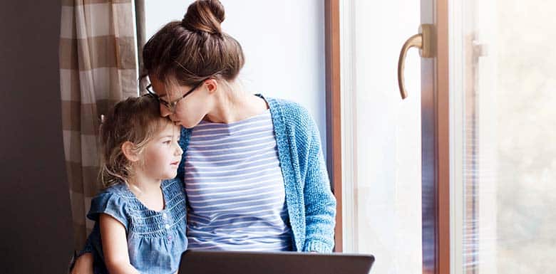 Mom kissing daughters forehead