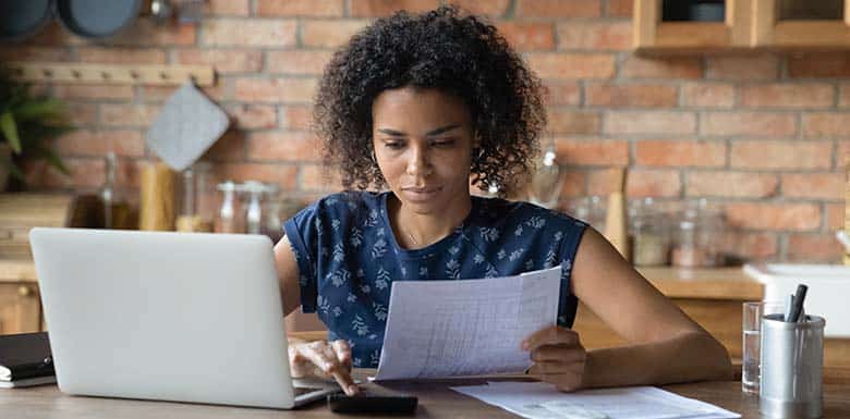 Woman sitting at kitchen table working on taxes
