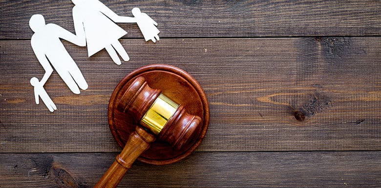 Judge gavel next to paper cut outs of family