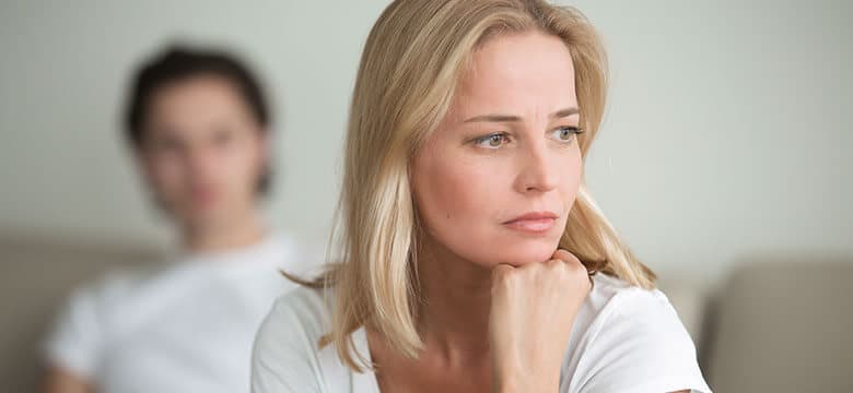 Woman sitting holding her head in hand