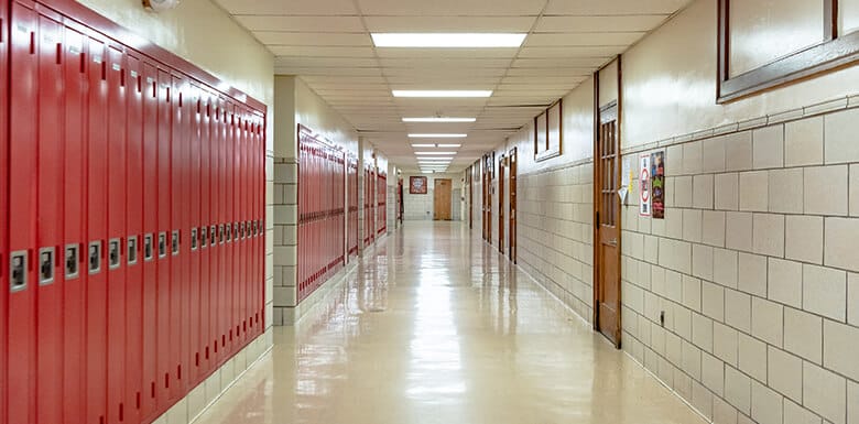 School hallway lined with red lockers