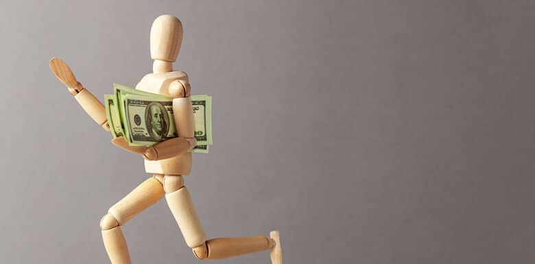 Wooden figure running with money