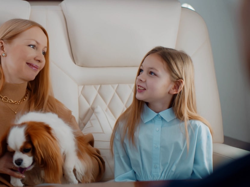 Mother with purebread dog on her lap with daughter in luxury private plane