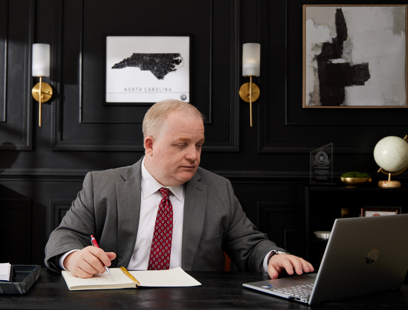Attorney Jonathan Breeden working on case at desk with laptop and notebook